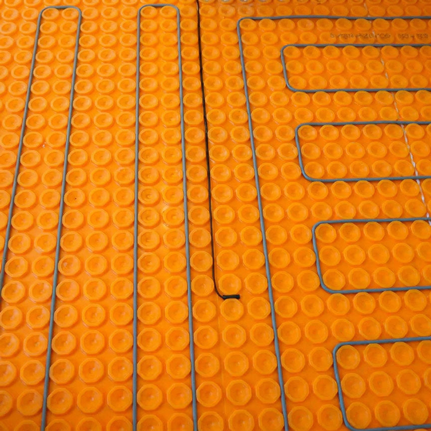 Step 2 — DITRA-HEAT-E-HK heating cable snapped between membrane studs in a serpentine pattern